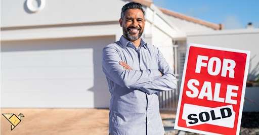 Zillow-premier-agent-standing-near-sold-sign-outside-house